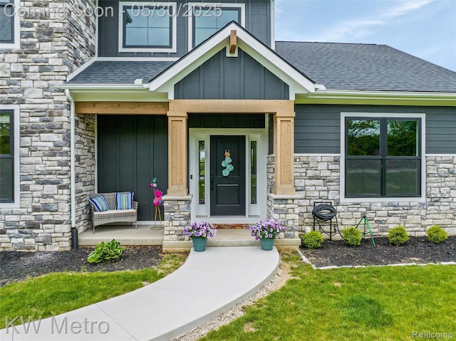 1585 Kriss Crossing Rd, Brighton, MI 48114 - entrance to property featuring stone siding, board and batten siding, roof with shingles, and a porch