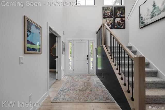 1585 Kriss Crossing Rd, Brighton, MI 48114 - foyer featuring stairway, wood finished floors, baseboards, and a high ceiling