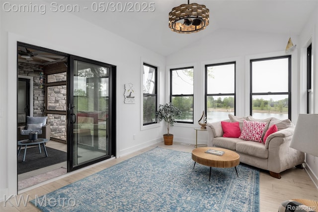 1585 Kriss Crossing Rd, Brighton, MI 48114 - living area featuring lofted ceiling, wood finished floors, baseboards, ceiling fan, and a water view