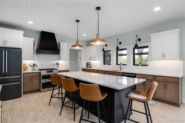 1585 Kriss Crossing Rd, Brighton, MI 48114 - kitchen with high quality fridge, custom exhaust hood, double oven range, tasteful backsplash, and a breakfast bar