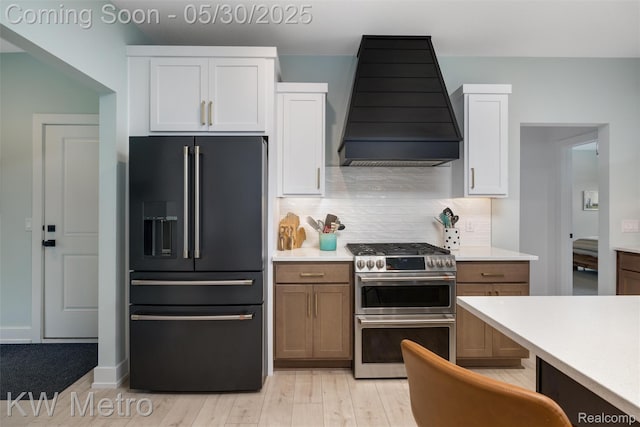 1585 Kriss Crossing Rd, Brighton, MI 48114 - kitchen with high end fridge, double oven range, custom range hood, and white cabinetry