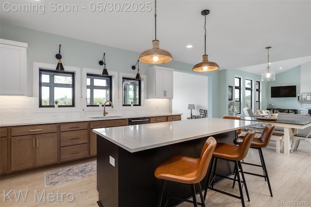 1585 Kriss Crossing Rd, Brighton, MI 48114 - kitchen featuring a sink, tasteful backsplash, light countertops, a center island, and a kitchen breakfast bar