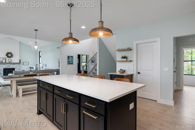 1585 Kriss Crossing Rd, Brighton, MI 48114 - kitchen featuring lofted ceiling, light wood finished floors, light countertops, decorative light fixtures, and recessed lighting