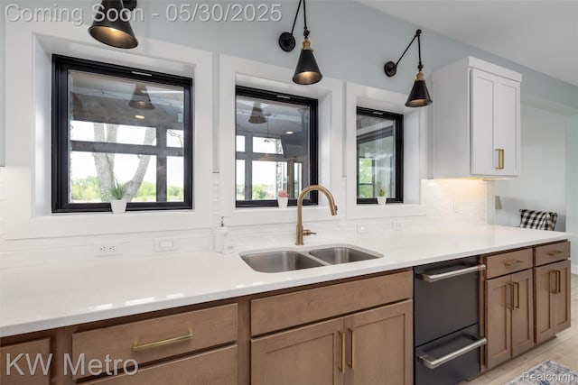1585 Kriss Crossing Rd, Brighton, MI 48114 - kitchen featuring a sink, light countertops, tasteful backsplash, and dishwasher