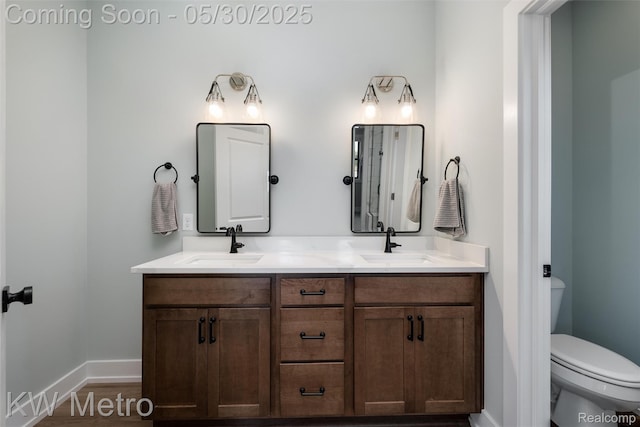 1585 Kriss Crossing Rd, Brighton, MI 48114 - full bathroom featuring double vanity, toilet, baseboards, and wood finished floors