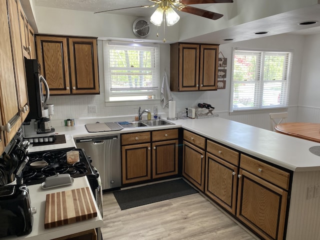 4516 Wah Wah Soo Dr, Gaylord, MI 49735 - kitchen featuring appliances with stainless steel finishes, a peninsula, a sink, a ceiling fan, and light wood finished floors