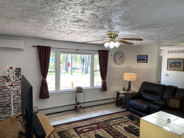 4516 Wah Wah Soo Dr, Gaylord, MI 49735 - living room featuring a wall mounted AC, a textured ceiling, wood finished floors, a ceiling fan, and a baseboard radiator