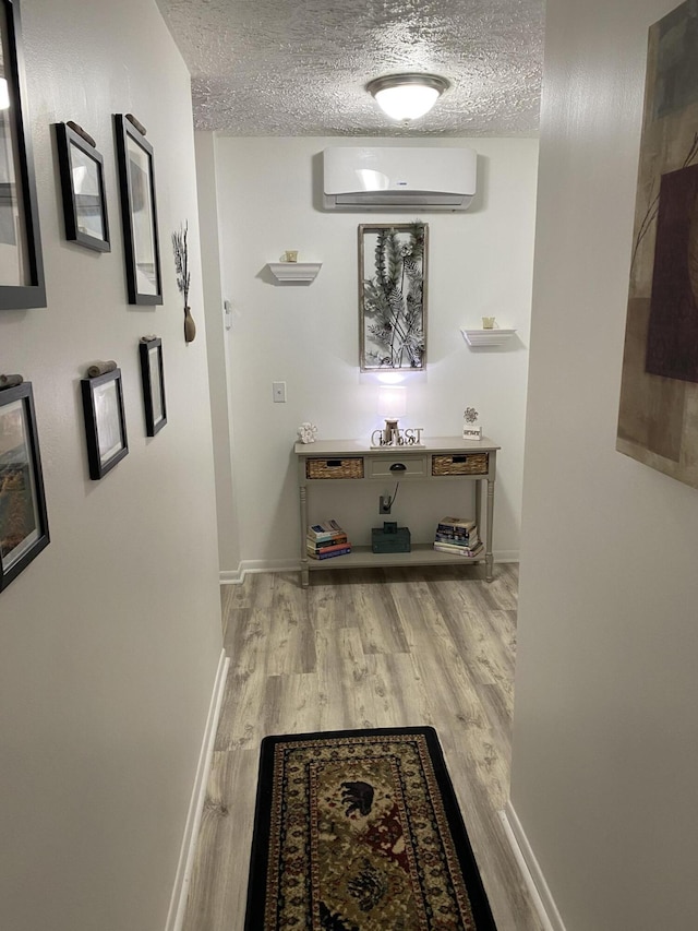 4516 Wah Wah Soo Dr, Gaylord, MI 49735 - corridor featuring a wall unit AC, a textured ceiling, wood finished floors, and baseboards