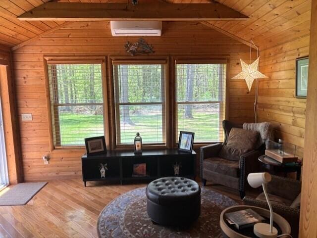 4516 Wah Wah Soo Dr, Gaylord, MI 49735 - sitting room with a wall unit AC, wood walls, wood ceiling, and wood finished floors