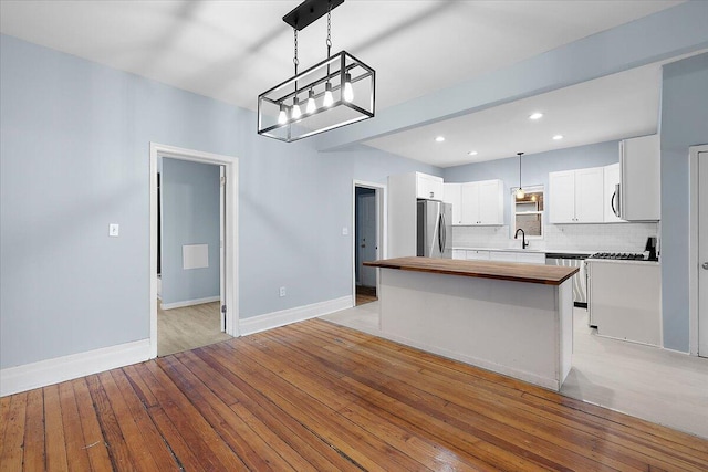 608 Mount Vernon St, Detroit, MI 48202 - kitchen featuring stainless steel appliances, wooden counters, a center island, light wood-type flooring, and white cabinets
