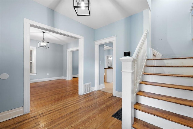 608 Mount Vernon St, Detroit, MI 48202 - stairs featuring a chandelier, hardwood / wood-style flooring, and baseboards