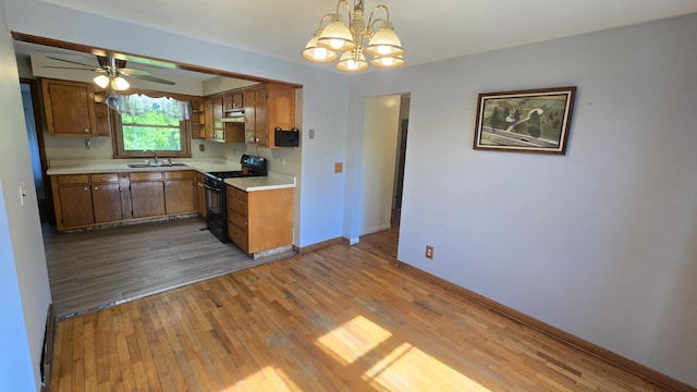 1301 US Highway 10, Scottville, MI 49454 - kitchen with black gas range oven, a sink, light countertops, and wood finished floors