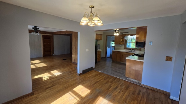 1301 US Highway 10, Scottville, MI 49454 - kitchen with a sink, a ceiling fan, a chandelier, brown cabinets, and light countertops
