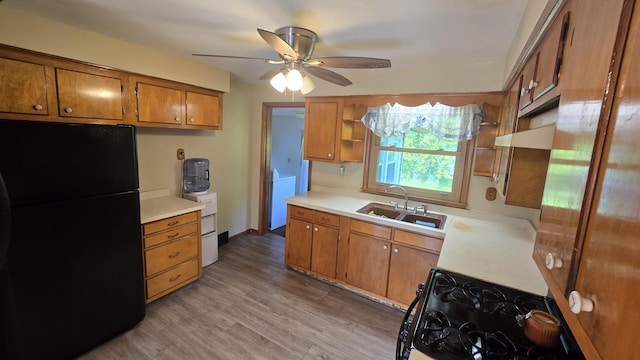 1301 US Highway 10, Scottville, MI 49454 - kitchen with freestanding refrigerator, a sink, brown cabinets, and gas range oven