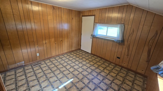 1301 US Highway 10, Scottville, MI 49454 - unfurnished room with tile patterned floors, wood walls, and lofted ceiling