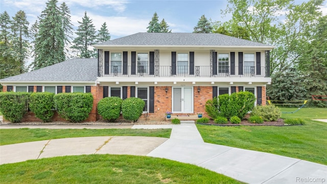 3072 Brewster, West Bloomfield, MI 48322 - view of front facade featuring a balcony, a front lawn, brick siding, and a shingled roof