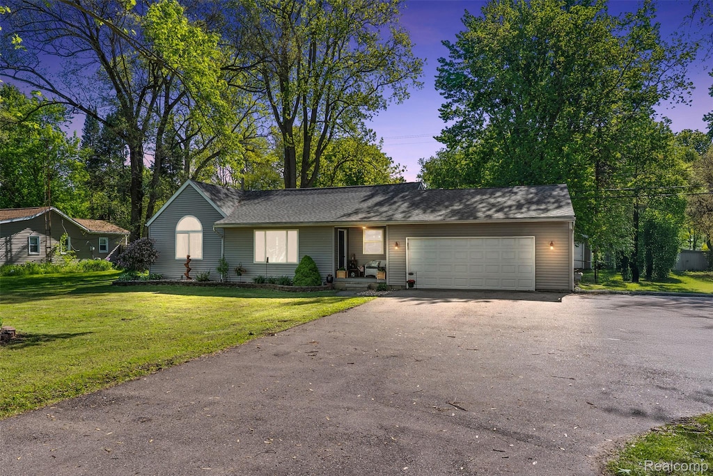 3296 N Genesee Rd, Flint, MI 48506 - view of front facade with driveway, an attached garage, and a yard