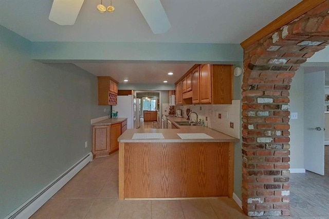 16172 Crest Dr, Linden, MI 48451 - kitchen with baseboard heating, a sink, light countertops, freestanding refrigerator, and recessed lighting