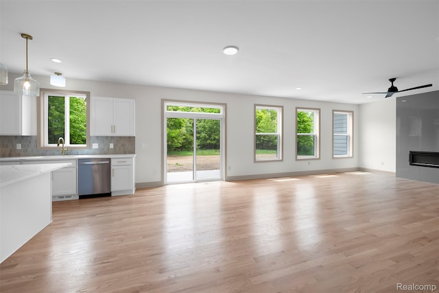 3097 Gecko Trl, Pinckney, MI 48169 - unfurnished living room with healthy amount of natural light, recessed lighting, light wood-type flooring, a large fireplace, and baseboards