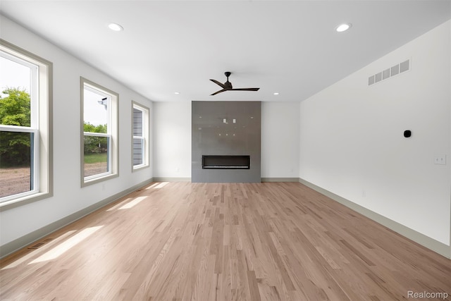 3097 Gecko Trl, Pinckney, MI 48169 - unfurnished living room featuring a ceiling fan, a large fireplace, light wood-style flooring, recessed lighting, and baseboards