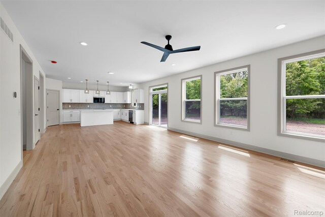 3097 Gecko Trl, Pinckney, MI 48169 - unfurnished living room with healthy amount of natural light, light wood finished floors, a ceiling fan, recessed lighting, and baseboards