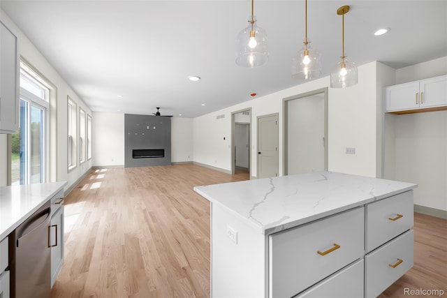 3097 Gecko Trl, Pinckney, MI 48169 - kitchen featuring stainless steel dishwasher, ceiling fan, light wood-type flooring, hanging light fixtures, and white cabinets