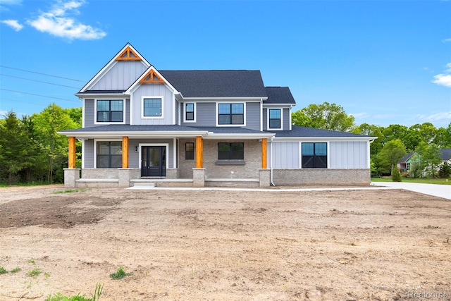 3097 Gecko Trl, Pinckney, MI 48169 - view of front facade with board and batten siding, covered porch, and a shingled roof