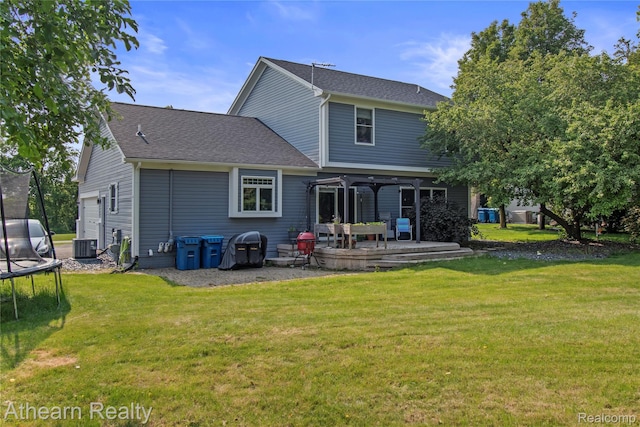 16429 E Horseshoe Trl, Linden, MI 48451 - rear view of property with a trampoline, a lawn, a deck, and a shingled roof