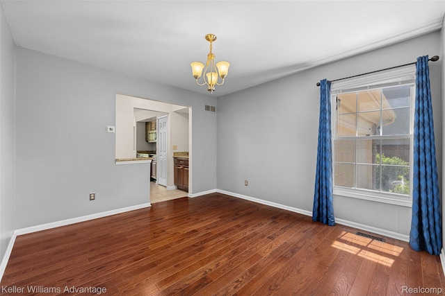 42900 Ledgeview Dr, Novi, MI 48377 - spare room featuring a chandelier, baseboards, and wood finished floors
