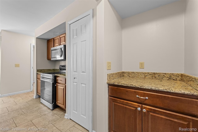 42900 Ledgeview Dr, Novi, MI 48377 - kitchen featuring appliances with stainless steel finishes, baseboards, light stone counters, light tile patterned floors, and brown cabinetry