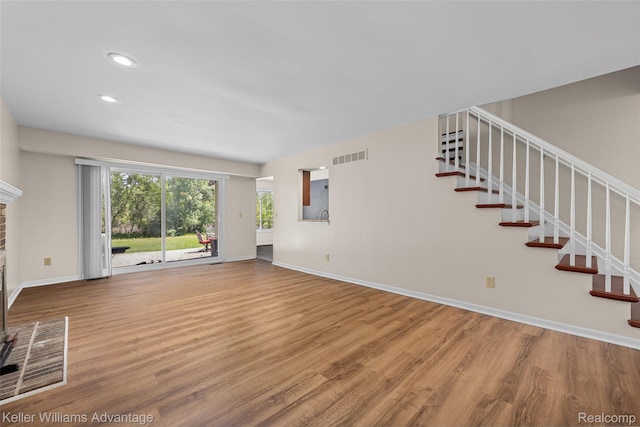 42900 Ledgeview Dr, Novi, MI 48377 - unfurnished living room with wood finished floors, baseboards, stairs, a brick fireplace, and recessed lighting