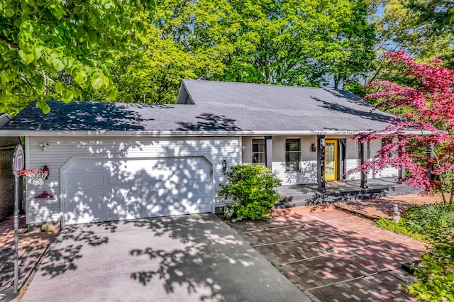 9180 Dicey St, Montague, MI 49437 - view of front facade featuring an attached garage, concrete driveway, a porch, and roof with shingles