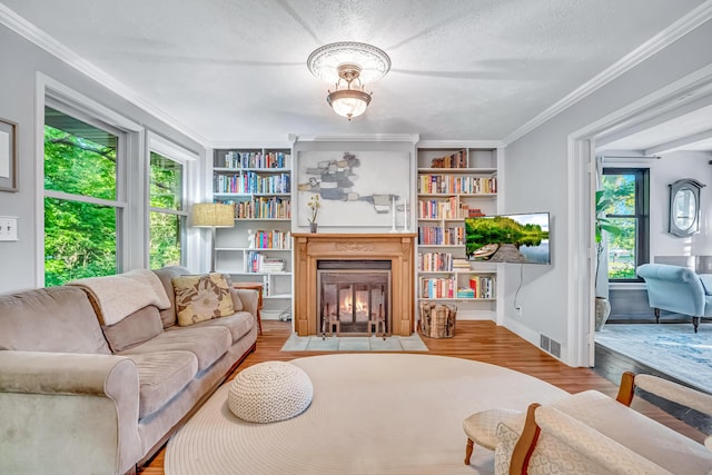 9180 Dicey St, Montague, MI 49437 - living room featuring plenty of natural light, wood finished floors, a fireplace with flush hearth, crown molding, and a textured ceiling