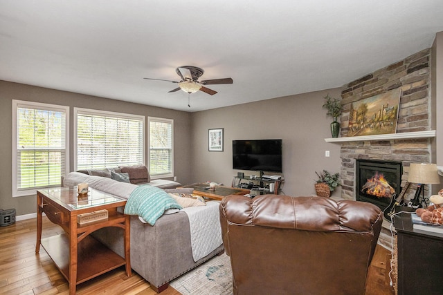 69218 Sundance Dr, Edwardsburg, MI 49112 - living area featuring light wood-type flooring, ceiling fan, a fireplace, and baseboards