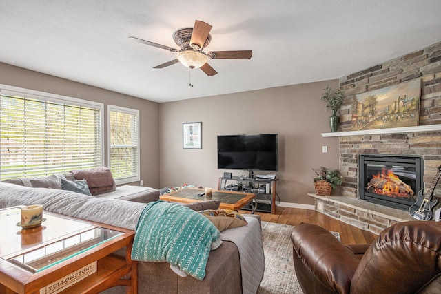 69218 Sundance Dr, Edwardsburg, MI 49112 - living room with wood finished floors, ceiling fan, a stone fireplace, and baseboards