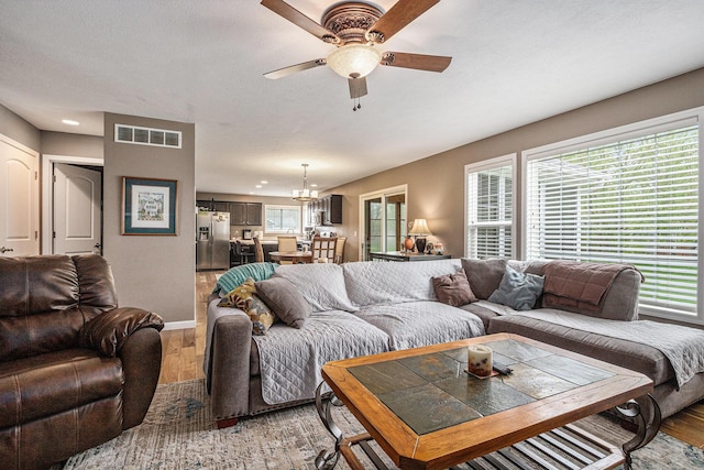 69218 Sundance Dr, Edwardsburg, MI 49112 - living area featuring light wood-style flooring, ceiling fan, a chandelier, and baseboards