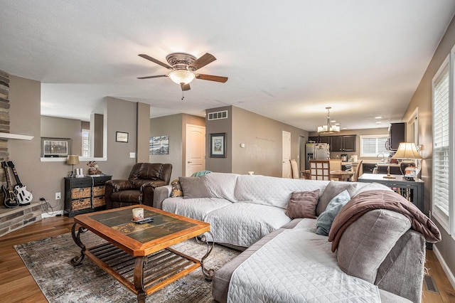 69218 Sundance Dr, Edwardsburg, MI 49112 - living area featuring a ceiling fan, a chandelier, wood finished floors, and baseboards