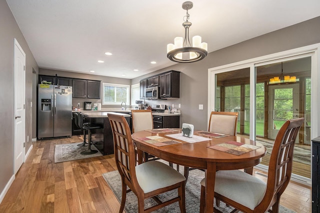 69218 Sundance Dr, Edwardsburg, MI 49112 - dining space with light wood finished floors, a chandelier, recessed lighting, and baseboards