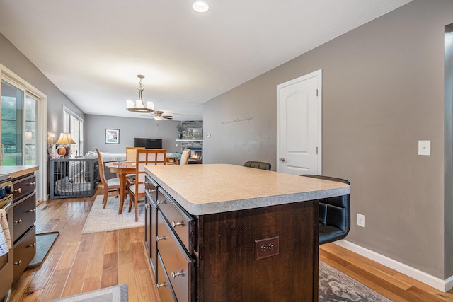 69218 Sundance Dr, Edwardsburg, MI 49112 - kitchen featuring light countertops, a chandelier, light wood finished floors, a breakfast bar area, and recessed lighting