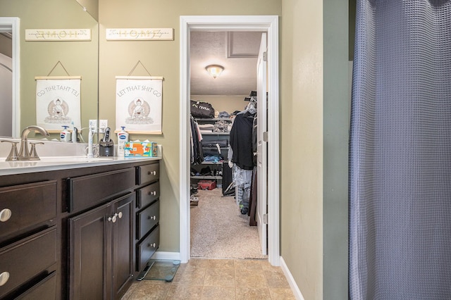 69218 Sundance Dr, Edwardsburg, MI 49112 - full bath featuring vanity, a walk in closet, curtained shower, and baseboards