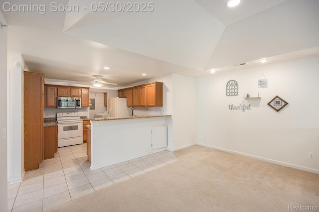 6769 Boulder Pointe Dr, Washington, MI 48094 - kitchen with white appliances, recessed lighting, brown cabinetry, a peninsula, and light carpet