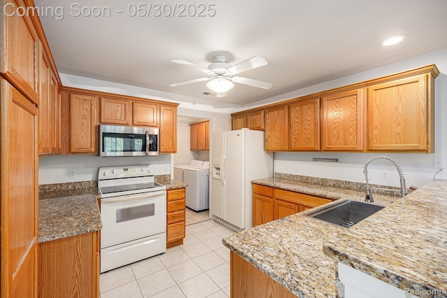 6769 Boulder Pointe Dr, Washington, MI 48094 - kitchen with white appliances, washer and dryer, a sink, light tile patterned floors, and a ceiling fan