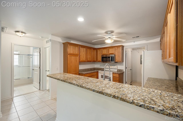 6769 Boulder Pointe Dr, Washington, MI 48094 - kitchen featuring white appliances, a peninsula, a ceiling fan, and brown cabinetry