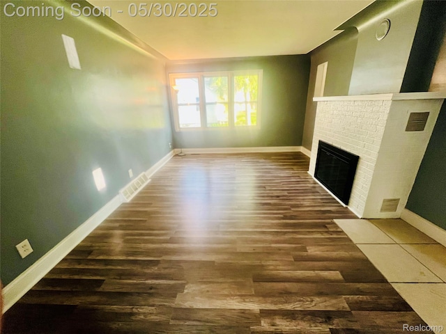 22380 Panama Ave, Sterling Heights, MI 48091 - unfurnished living room with wood finished floors, baseboards, and a brick fireplace