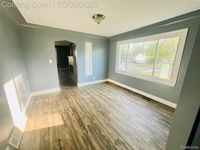 22380 Panama Ave, Sterling Heights, MI 48091 - empty room with arched walkways, wood finished floors, and baseboards