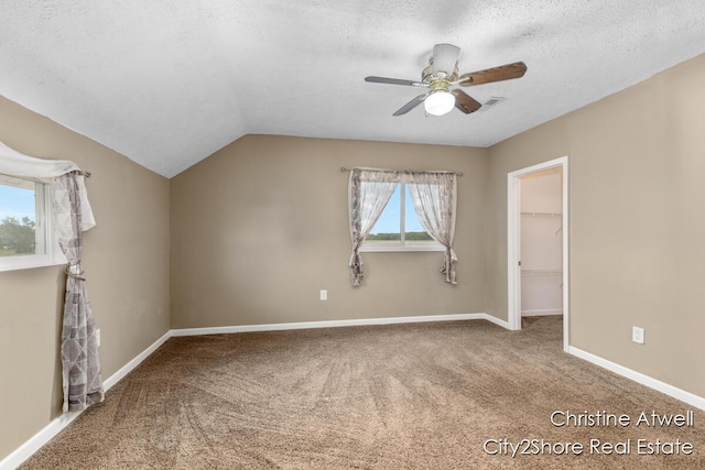11943 Mulliken Rd, Mulliken, MI 48861 - carpeted spare room with a ceiling fan, a textured ceiling, lofted ceiling, and baseboards