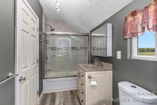 11943 Mulliken Rd, Mulliken, MI 48861 - full bath with a textured ceiling, vanity, shower / bath combination with glass door, toilet, and wood finished floors