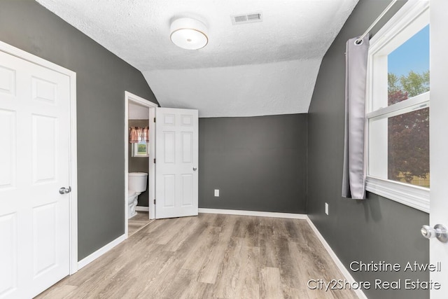 11943 Mulliken Rd, Mulliken, MI 48861 - additional living space featuring lofted ceiling, a textured ceiling, wood finished floors, and baseboards