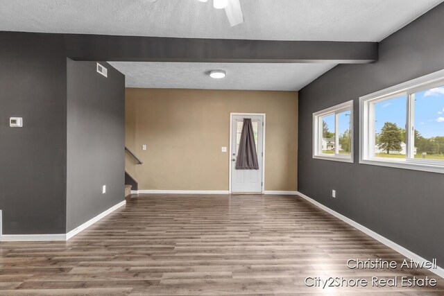 11943 Mulliken Rd, Mulliken, MI 48861 - spare room featuring wood finished floors, beamed ceiling, stairway, baseboards, and a textured ceiling