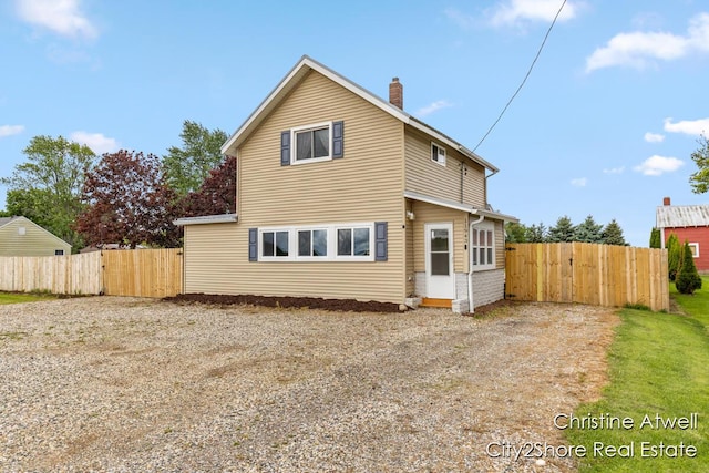 11943 Mulliken Rd, Mulliken, MI 48861 - rear view of house with driveway, a chimney, and a gate